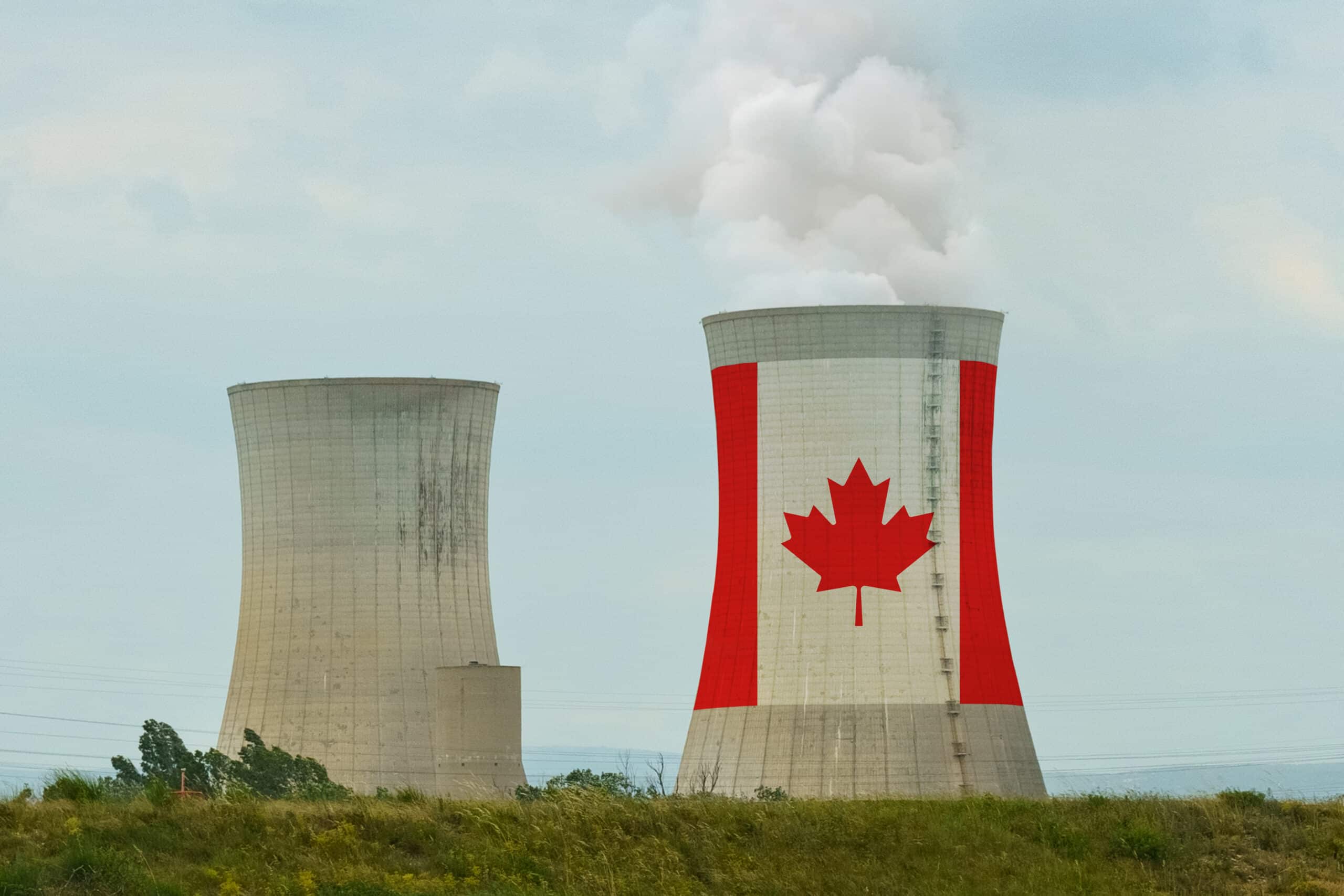 Two industrial cooling towers, one painted with a large Canadian flag and emitting steam, representing the Saskatchewan nuclear industry.